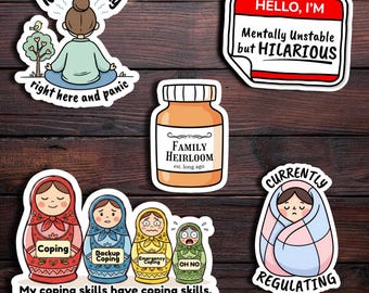May include: A collection of humorous stickers on a wooden background. The stickers feature phrases like "Nama-stay right here and panic," "Mentally Unstable but HILARIOUS," and "My coping skills have coping skills." Other stickers include a jar labeled "Family Heirloom" and a person wrapped in a blanket labeled "Currently Regulating."