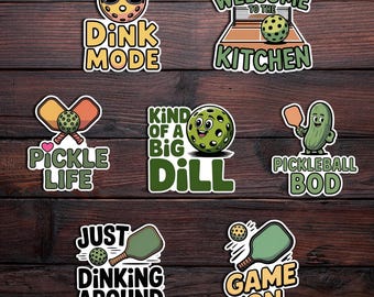 May include: A collection of colorful pickleball-themed stickers. Designs include a pickleball with sunglasses, a pickleball court, a pickle with a paddle, and text such as "Dink Mode," "Pickle Life," and "Game On."
