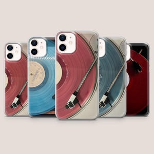 Op de afbeelding: Een verzameling telefoonhoesjes met een vinylplaatontwerp. De hoesjes tonen een platenspeler met rode, blauwe en donkerrode platen. De hoesjes hebben een doorzichtige rand en een zwart-witte naald.