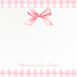 May include: A white stationery sheet with a pink bow at the top and a pink gingham border. The text "Mackenzie Dyer Gaines" is written in cursive at the bottom of the sheet.