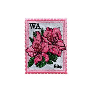 May include: Embroidered patch in the shape of a postage stamp featuring pink flowers and green leaves. The patch has a pink scalloped border and the text "WA" and "50p".