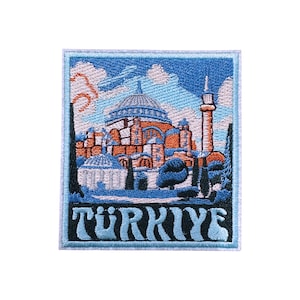 Può includere: Toppa ricamata raffigurante un edificio con cupola e minareto, su uno sfondo di cielo blu con nuvole. La parola "TÜRKIYE" è ricamata in un carattere stilizzato in basso, con un bordo blu. Souvenir di viaggio.