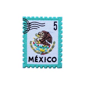 Puede incluir: Parche bordado con forma de sello postal con borde turquesa. El parche presenta un águila marrón posada sobre una corona, el número 5 y la palabra MÉXICO en letras blancas.