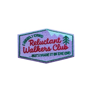 Peut inclure: Écusson brodé lavande avec le texte « I hiked, I cried, Reluctant Walkers Club, but I made it in the end ». Le patch présente un motif de montagne et d'arbre en vert et bleu clair.
