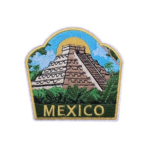 May include: Embroidered patch featuring a depiction of the Mayan pyramid at Chichen Itza, with a rising sun and lush green foliage. The word "MEXICO" is embroidered in gold letters at the bottom. The patch has a gold border.