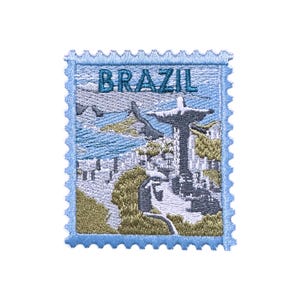 May include: Embroidered patch in the shape of a postage stamp. The patch features a light blue border and the word "BRAZIL" in teal. The image depicts a landscape with a statue and the ocean.