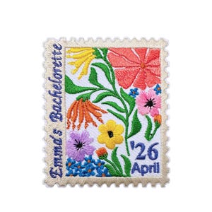 Peut inclure: Écusson brodé en forme de timbre-poste, orné d'un motif floral coloré. L'écusson présente des fleurs rouges, jaunes, oranges, violettes et bleues, avec des feuilles vertes. Le texte sur l'écusson indique "Emma's Bachelorette" et "26 Avril".