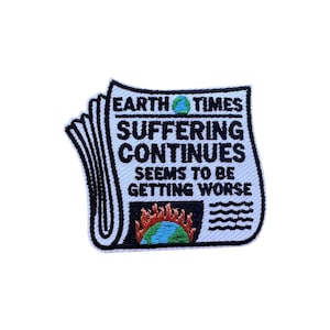 以下が含まれることがあります： 黒い縁取りのある新聞の形をした白いパッチ。テキストは「EARTH TIMES SUFFERING CONTINUES SEEMS TO BE GETTING WORSE」と書かれています。画像には炎のある地球が含まれています。