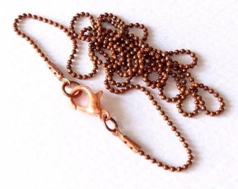 Op de afbeelding: Een koperen ballenketting met een karabijn sluiting.