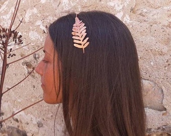 Op de afbeelding: Een gouden haar kam in de vorm van een varenblad. De kam wordt gedragen in het haar van een vrouw.