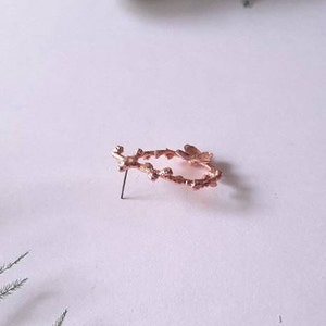 Pu&ograve; includere: Un orecchino a forma di ramo in oro rosa con un delicato design a farfalla. L'orecchino &egrave; in metallo e ha un retro a perno.