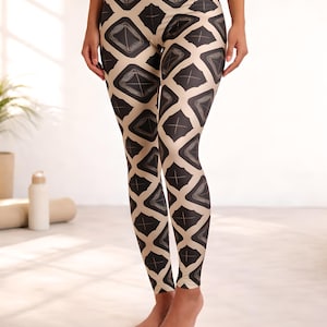 May include: High-waisted leggings with a geometric pattern in black and tan. The leggings feature a repeating diamond design with a cross in the center of each diamond. The leggings are form-fitting and made of a stretchy material.