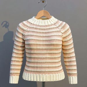 May include: A white ceramic mug with a black handle and the text "But First, Coffee" in a bold, black font. The mug is set against a neutral background, highlighting its simple design.