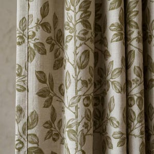 Può includere: Primo piano di una tenda beige con un motivo botanico verde oliva ripetuto. Il design presenta foglie stilizzate, rami e piccoli frutti. Il tessuto è strutturato e presenta pieghe verticali.