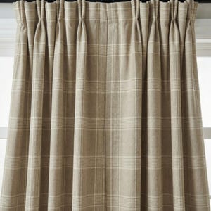May include: Beige plaid curtain panels. The curtains are made of a thick fabric and feature a classic plaid pattern in shades of beige and off-white. The curtains are hanging from a dark rod.