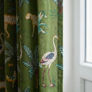Könnte beinhalten: Grüner Stoffvorhang mit einem Dschungelmotiv. Das Muster zeigt einen Flamingo, einen Leoparden und tropische Pflanzen. Der Flamingo hat einen weißen Körper, rosa Beine und einen gebogenen Hals. Der Leopard hat ein geflecktes Fell.