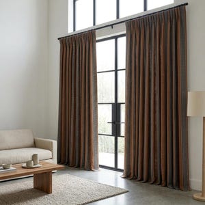 Pu&ograve; includere: Tende plissettate dal pavimento al soffitto in un ricco color marrone ruggine, caratterizzate da strisce verticali con sottili motivi bianchi e neri. Le tende sono appese a un bastone in metallo nero davanti a una grande finestra con telaio nero.