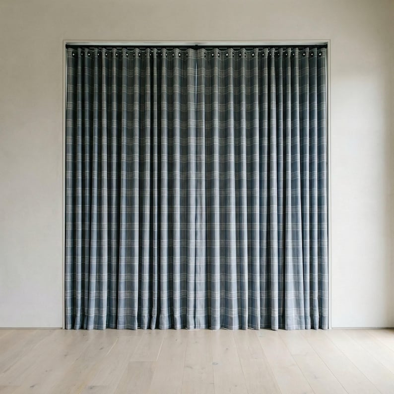 May include: A pair of blue and white plaid curtains hanging in a window. The curtains are made of a textured fabric and have a classic, elegant design. The curtains are hanging in front of a white wall and a light-colored wooden floor.