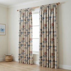 May include: Beige curtains with a repeating pattern of blue, red, and gray fish. The curtains are hanging on a wooden rod in front of a window. The room has a light, airy feel.