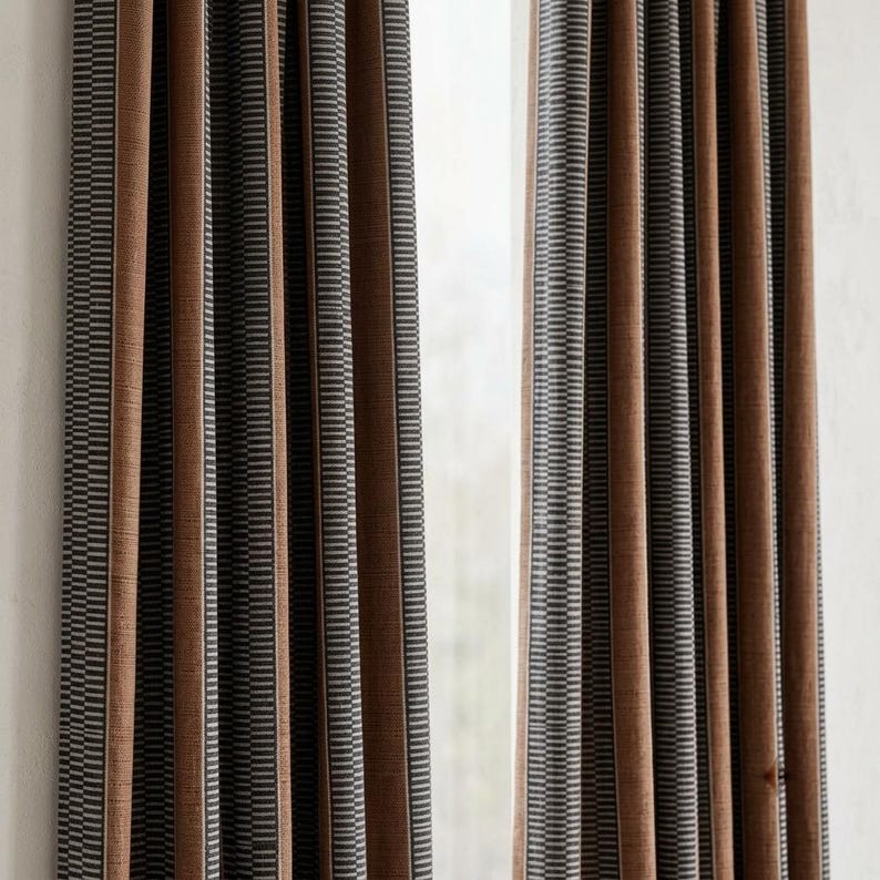 Pu&ograve; includere: Due pannelli per tende a tutta altezza caratterizzati da un motivo a righe verticali. Il design &egrave; composto da un'alternanza di ampie fasce marroni a tinta unita e fasce pi&ugrave; strette con micro-righe grigio scuro e bianco, creando una texture.