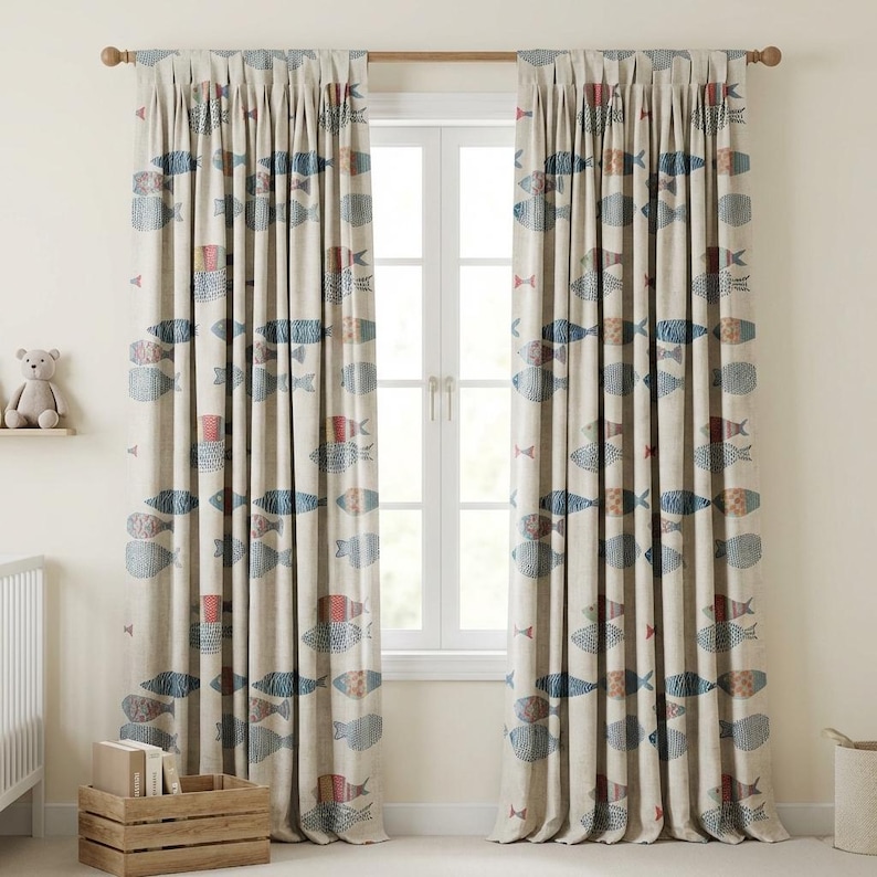 May include: Beige window curtains with a repeating pattern of blue and red fish. The curtains are hanging in front of a white window. A wooden curtain rod is visible at the top. The curtains are pleated and have a textured appearance.