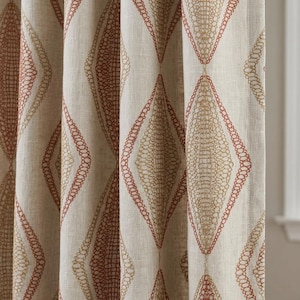 May include: A beige curtain panel featuring a repeating vertical pattern of large diamonds. Each diamond is outlined in a rust-colored thread and filled with a gold-toned, intricate, circular, and chain-like embroidery design on a textured fabric.