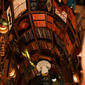 Puede incluir: Vista detallada de una estructura de estanter&iacute;a de madera llena de libros, sombreros y objetos decorativos. Los estantes est&aacute;n dispuestos en un patr&oacute;n curvo, creando una exhibici&oacute;n visualmente interesante. La paleta de colores est&aacute; dominada por marrones y naranjas c&aacute;lidos.