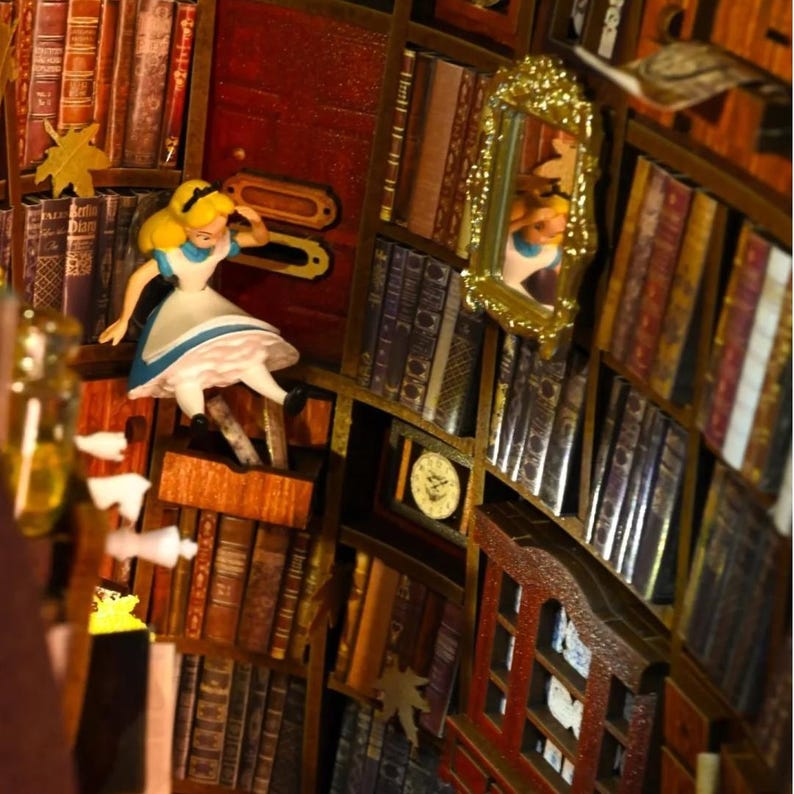 Puede incluir: Una escena en miniatura de una biblioteca con numerosos libros y una peque&ntilde;a figura de Alicia en el Pa&iacute;s de las Maravillas. La escena incluye un espejo con marco dorado, un reloj y elementos decorativos, todo dentro de una estructura de madera.