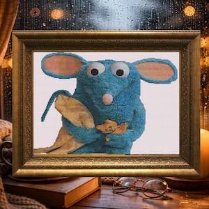 May include: A framed cross-stitch picture of a blue cartoon rat holding a leaf and a small yellow figure. The artwork is in a gold frame. The background includes a window with raindrops, a candle, and a book.