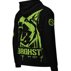 Könnte beinhalten: Schwarzer Kapuzenpullover mit einem neongrünen Aufdruck eines knurrenden Hundekopfes auf dem Rücken. Das Wort "BRGHST" ist darunter gedruckt. Ein kreisförmiges Logo befindet sich auf dem rechten Ärmel. Der Hoodie hat eine Kapuze und lange Ärmel.