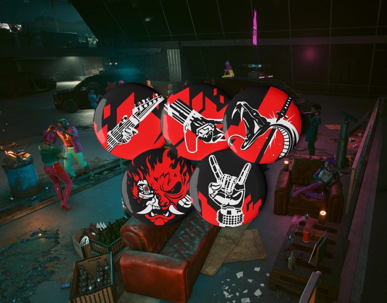 May include: A collection of six round black and red buttons with various white graphic designs. The designs include a guitar, a gun, a snake, a demon face, and a rock and roll hand gesture. The buttons are displayed in a dimly lit setting.