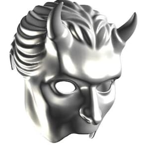 Op de afbeelding: Een zilveren masker met een demonisch ontwerp. Het masker heeft twee gebogen hoorns, een gestileerd kapsel en oogopeningen. Het gezicht heeft een duidelijke neus en een licht geopende mond. Het masker is gemaakt van glanzend metaal.