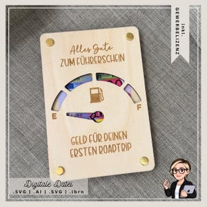 Puede incluir: Un tarjetero de madera con las inscripciones grabadas en alemán, incluyendo "Alles Gute ZUM FÜHRERSCHEIN" y "GELD FÜR DEINEN ERSTEN ROADTRIP". El diseño incluye un indicador de combustible con billetes de euro visibles. Remaches dorados aseguran el tarjetero.