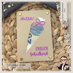 May include: A beige card with a cut-out cone shape revealing a portion of a banknote. The card features the words "Hurra!" and "ENDLICH Schulkind" in purple script, along with gold heart accents. The text "Digitale Datei" is at the bottom.