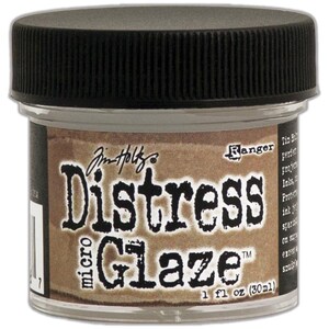 May include: A clear jar of Distress Micro Glaze with a black lid. The label features the text "Distress Micro Glaze" and "1 fl oz (30ml)". The brand name "Jim Holtz" and the "Ranger" logo are also visible on the label. The product is designed for various craft projects.