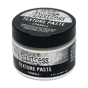 Puede incluir: Un tarro blanco de pasta de textura Distress con un acabado brillante. El tarro está etiquetado con el nombre del producto y el tamaño: 3 fl oz (88,7 ml).