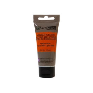 May include: A brown tube of modelling paste with the text "art basics Modelling Paste Pate de Structure Asta de Modelado Opaque Matte Opaque Mat Opaco Mate 2 FL. OZ. (59 ml)"