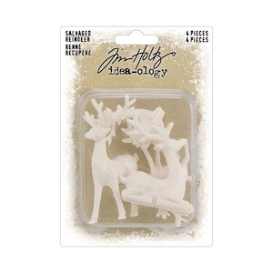 Puede incluir: Cuatro figuritas de reno de plástico blanco en un paquete de plástico transparente. El paquete tiene un fondo marrón con copos de nieve blancos y el texto "Salvaged Reindeer" y "Jim Holtz idea-ology".