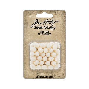 May include: A package of 50 white plastic tiny eggs for crafting. The package is labeled "Jim Holtz idea-ology Tiny Eggs Petits Oeufs 50 Pieces/50 Pieces".