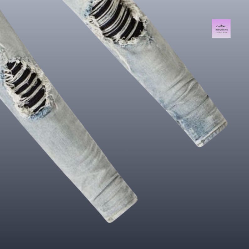 以下が含まれることがあります： ライトブルーのデニムジーンズ。ダメージ加工が施されており、破れた部分から黒い生地が見えています。画像はジーンズの脚の下部をクローズアップし、その質感とデザインを強調しています。