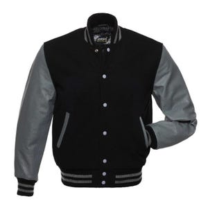 May include: A black varsity jacket with gray sleeves. The jacket has a button-up front, two front pockets, and gray and black striped cuffs and waistband. The collar is black with gray stripes. The jacket has the Europa Style logo on the collar.