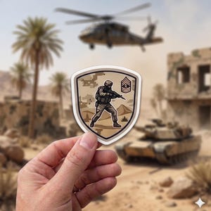 Könnte beinhalten: Beige-brauner Aufkleber mit einem Soldaten mit Gewehr vor einer Wüstenkulisse mit Hubschrauber und Panzer. Der Aufkleber hat eine Schildform mit weißem Rand und Sergeantstreifen.