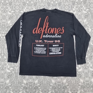 May include: A black long-sleeve t-shirt featuring the band name "deftones" in red script with "adrenaline" below. The shirt lists the U.K. Tour 98 dates and venues in red text.