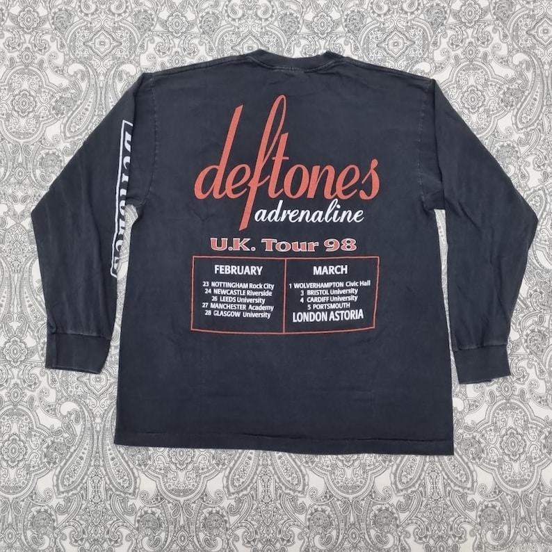 May include: A black long-sleeve t-shirt featuring the band name "deftones" in red script with "adrenaline" below. The shirt lists the U.K. Tour 98 dates and venues in red text.