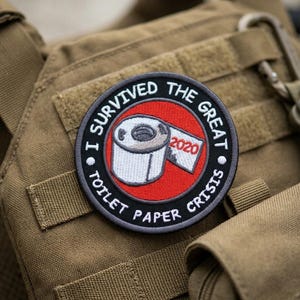 May include: A white ceramic mug with a black handle and the text "But First, Coffee" in a black, bold font. The mug is on a white surface.