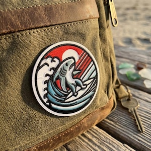 May include: A set of three ceramic mugs with a speckled, matte finish. The mugs are in shades of cream, light gray, and dark gray. Each mug has a simple, minimalist design and a rounded handle.