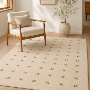 May include: A rectangular area rug featuring a light beige base color with a repeating pattern of small, dark brown embroidered cross symbols arranged in vertical columns across the entire surface of the floor covering.