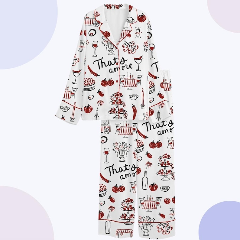 May include: White pajama set with a repeating pattern of red and black Italian food illustrations, including wine glasses, cakes, and tables. The words "That's amore" are printed on the shirt and pants.