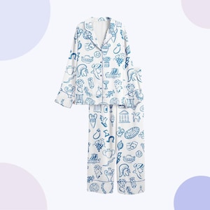 May include: White pyjama set with a blue Greek-themed pattern. The set includes a button-down top and matching trousers. The pattern features illustrations of Greek figures, vases, and other classical elements.