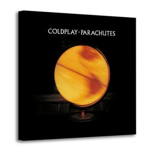 May include: A white ceramic mug with a black handle and the text "But First, Coffee" in a black, bold font. The mug is on a white surface.